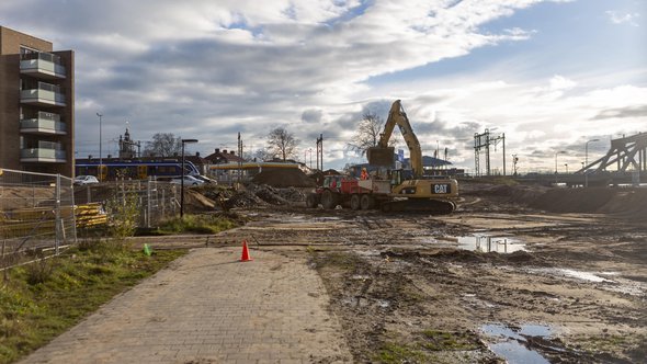 ZUTPHEN, NETHERLANDS - Dec 04, 2020: Empty space with heavy machinery working on a lot preparing the soil and location for construction of residential apartment building at Kade Zuid door Wirestock Creators (bron: shutterstock)