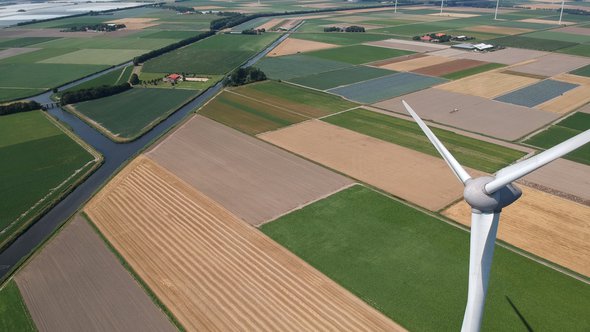 Drone photo of a large windmill with a total height of 198 meters with a shaft height of 135 meters. In the background, the wieringermeer polder.Photo taken at an altitude of 204 meters door Mauvries (bron: Shutterstock)
