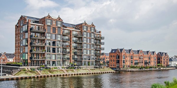 recent gebouwde woongebouwen aan de oevers van de rivier de Oude Rijn, die het uiterlijk van omgebouwde oude pakhuizen imiteren door Frans Blok (bron: Shutterstock)