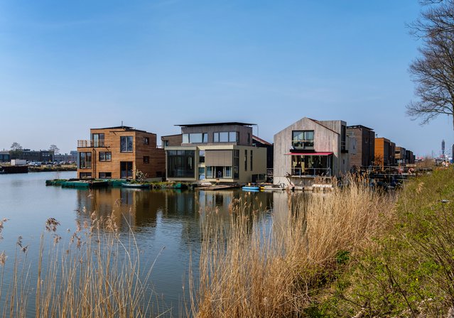 Amsterdam, april 2020. Buurt met houten huizen, drijvend op het water door www.hollandfoto.net (bron: Shutterstock)