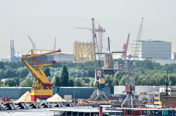 Uitzicht op de industriegebieden van Merwe Vierhavens in Rotterdam en Schiedam, met havenkranen en ander materieel, evenals een traditionele windmolen door Frans Blok (bron: Shutterstock)