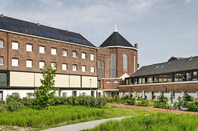 Een voormalige gevangenis dat is verbouwd tot woningen met collectieve tuinen. door Frans Blok (bron: Shutterstock)