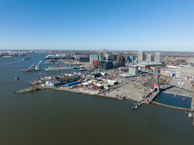 Amsterdam, 19th of March 2022, The Netherlands. NDSM wharf modern industrial shipyard and trendy residential area. Amsterdam Noord along the Ij river and waterway. door Make more Aerials (bron: Shutterstock)