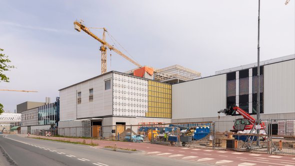 Veldhoven, The Netherlands, May 8th 2020. A construction site of the new ASML buildings with a big yellow crane and construction materials on a sunny day during spring door Lea Rae (bron: shutterstock)