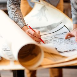 Projecteren met potlood op de grote stedelijke tekeningen. door RossHelen (bron: Shutterstock)