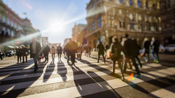 Menigte anonieme mensen die op drukke stadsstraat lopen door BABAROGA (bron: Shutterstock)