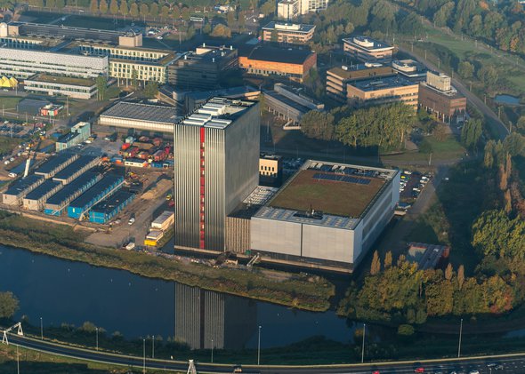 18-9-2018, Amsterdam, Holland. Aerial view of Equinix Datacenter. A skyscraper with no windows. The structure of the high rise building reflects in the water and gives a long early morning shadow. door Aerovista Luchtfotografie (bron: Shutterstock)