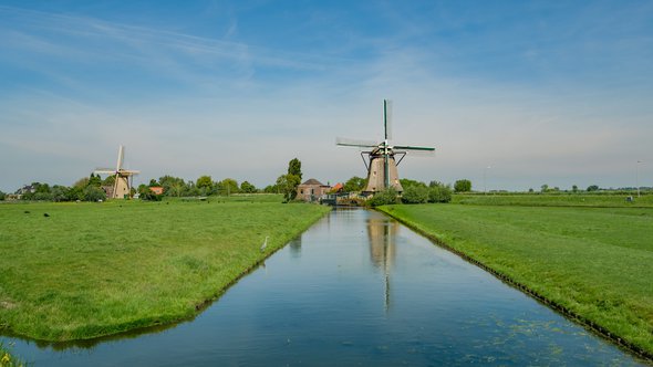 Two wind mills in a polder landscape near the village of Maasland, the Netherlands. Maasland is a village in the province of South Holland in the Netherlands door Frank Cornelissen (bron: shutterstock)