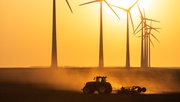 Tractor cultiveert landbouwgrond tijdens zonsondergang bij een rij windturbine. Groningen, Nederland. door Sander van der Werf (bron: Shutterstock)