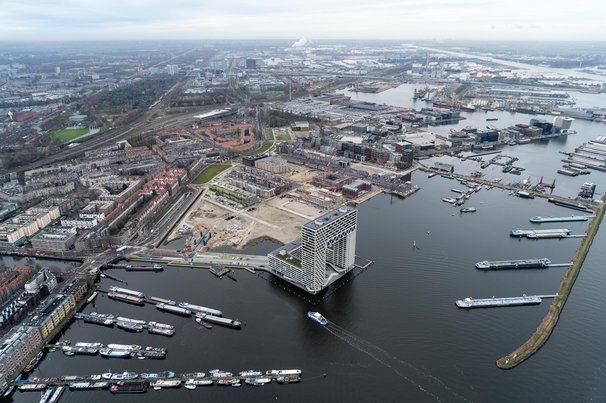 Aerial view of housing construction site in the Houthavens. Skyscraper apartment building Pontsteiger in the front with boats in the harbour. door Aerovista Luchtfotografie (bron: Shutterstock)