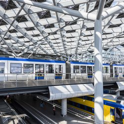 The Hague, The Netherlands - August 6, 2017: Central Train Station The Hague with construction, train, HTM tram, platforms and glass windows. door Daan Kloeg (bron: Shutterstock)