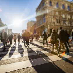 Menigte anonieme mensen die op drukke stadsstraat lopen door BABAROGA (bron: Shutterstock)