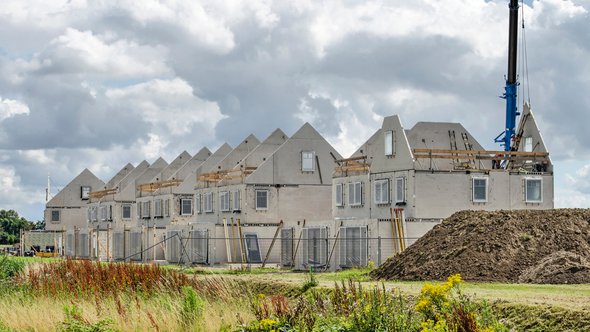 Numansdorp, The Netherlands, July 10, 2020: construction site of a row of terrace houses, with prefab concrete walls awaiting finishing under a dramatic sky door Frans Blok (bron: Shutterstock)