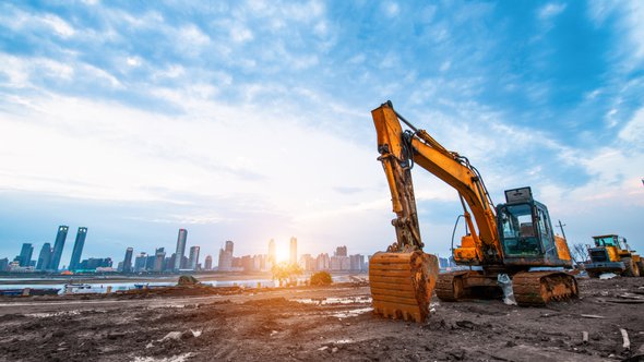 Excavator in construction site on sunset sky background door Wang An Qi (bron: Shutterstock)