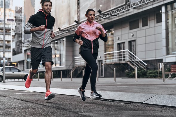Eruit voor een run. volledige lengte van jong stel in sport kleding lopen door de stad straat samen door G-Stock Studio (bron: Shutterstock)