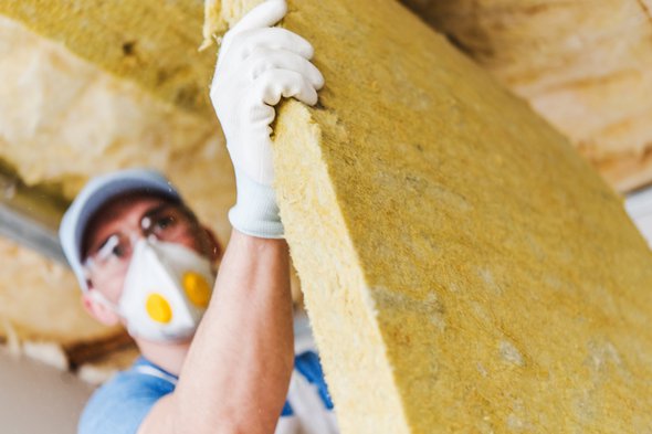 Caucasian Construction Worker with Piece of Insulating Material, Roof Insulating by Mineral Wool. door Virrage Images (bron: Shutterstock)
