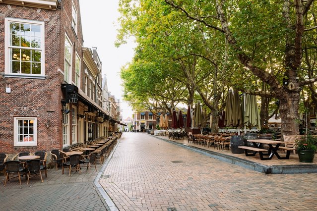 Delft, 26 augustus 2025. Lege cafe terrasstoelen in de oude stad. door Octavian Lazar (bron: Shutterstock)