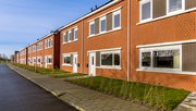 Gloednieuwe ontwikkeling van eenvoudige volkshuisvesting in een dorp in Nederland. Buurtscène van straat met moderne rijtjeshuizen in de voorsteden. door Rudmer Zwerver (bron: Shutterstock)