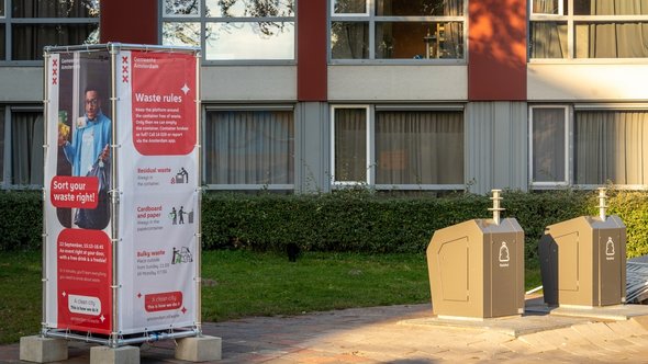 Afvalsorteerregels infobord naast stedelijke ondergrondse vuilnisbakke door Milos Ruzicka (bron: Shutterstock)