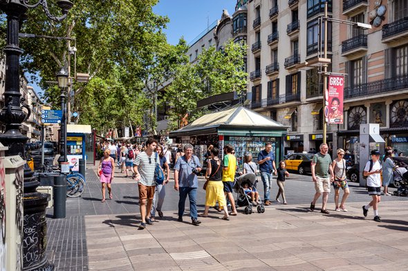 Spain, Barcelona: Street scene with people residents tourists women men children on famous boulevard La Rambla in the city center of the Spanish town, kiosk, green trees and cars. July 01, 2018 door Rolf G Wackenberg (bron: shutterstock)