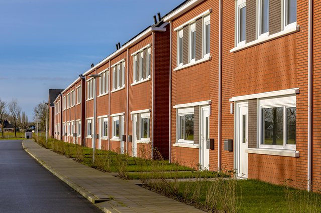 Brand new development of basic public housing in a village in the Netherlands. Neighborhood scene of street with modern suburban terraced houses. door Rudmer Zwerver (bron: shutterstock)