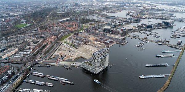 Luchtfoto van woningbouwlocatie in de Houthavens. Wolkenkrabber appartementengebouw Pontsteiger aan de voorzijde met boten in de haven. door Aerovista Luchtfotografie (bron: Shutterstock)