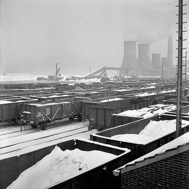 Gezicht op het besneeuwde emplacement van de NS te Heerlen met rechts op de achtergrond de koeltorens van de Oranje Nassau door Nederlandse Spoorwegen, (bron: Wikipedia Commons)