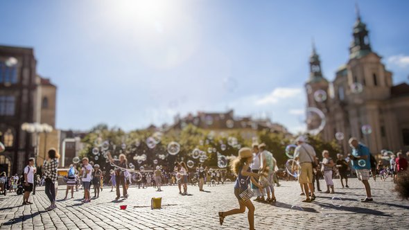 gelukkige zomerdag en kinderen spelen op het oude stadsplein in Praag door BABAROGA (bron: Shutterstock)