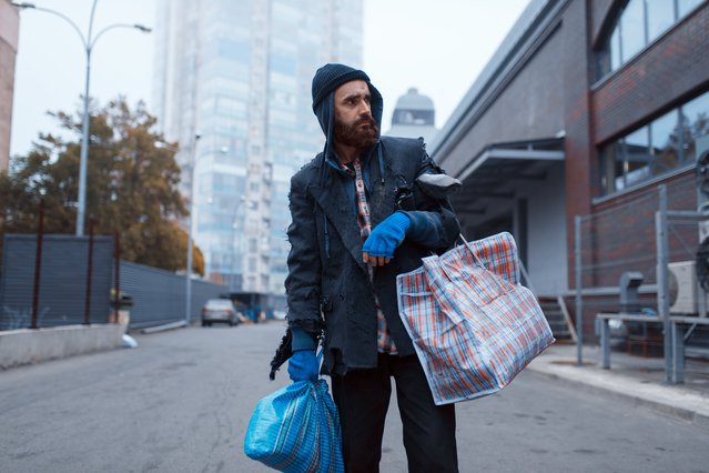 Bearded tramp man with bag on city street door Nomad_Soul (bron: Shutterstock)
