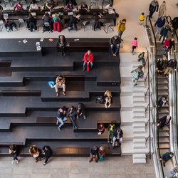 Mensen op de trappen en roltrappen in het Groninger Forum in Nederland door Marc Venema (bron: Shutterstock)