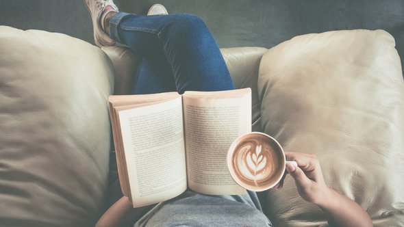 Soft photo of young girl reading a book and drinking coffee door Ko Backpacko (bron: Shutterstock)