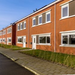 Gloednieuwe ontwikkeling van eenvoudige volkshuisvesting in een dorp in Nederland. Buurtscène van straat met moderne rijtjeshuizen in de voorsteden. door Rudmer Zwerver (bron: Shutterstock)