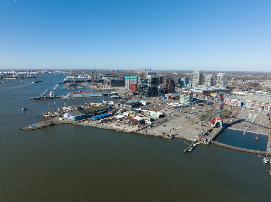 Amsterdam, 19th of March 2022, The Netherlands. NDSM wharf modern industrial shipyard and trendy residential area. Amsterdam Noord along the Ij river and waterway. door Make more Aerials (Shutterstock)
