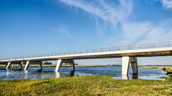 Kampen, The Netherlands, July 29, 2019: new concrete bridge across the Reevediep flood channel of the IJssel river under a blue sky on a summer morning door Frans Blok (bron: shutterstock)