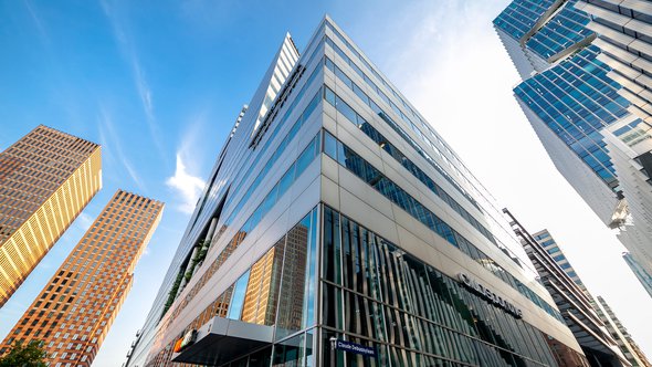 Architectuur van hedendaagse moderne hoogbouw in het financiële district in Amsterdam met reflecterende buitengevels door Maarten Zeehandelaar (bron: Shutterstock)