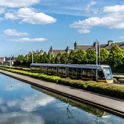 trein naast huizen -> DRIMNAGH LUAS TRAM STOP [GOLDENBRIDGE CE" (CC BY-SA 2.0) by infomatique door William Murphy (bron: Wikimedia Commons)