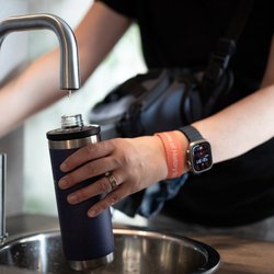 persoon vult een herbruikbare waterfles door LIGHTITUP (bron: Shutterstock)