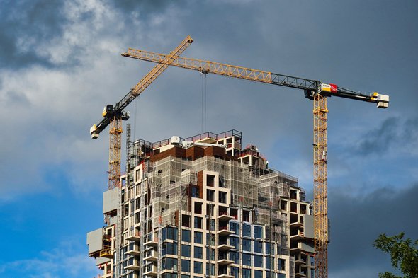 Den Haag, Netherlands - November 03 2021 : two cranes are standing around a building under construction door oliverdelahaye (bron: shutterstock)