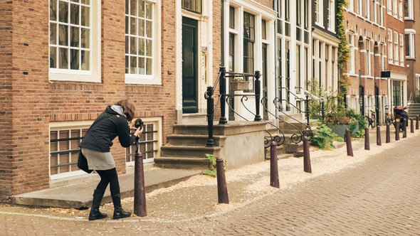 Vrouw fotografeert straat in Amsterdam door Raysto (bron: Shutterstock)