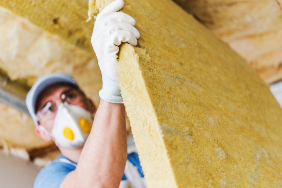 Caucasian Construction Worker with Piece of Insulating Material, Roof Insulating by Mineral Wool. door Virrage Images (Shutterstock)