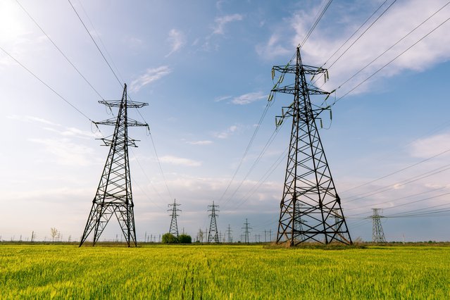 Hoogspanningslijnen die door een groen veld lopen door yerv (bron: Shutterstock)