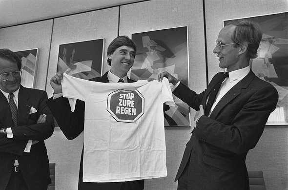 Oude en nieuwe minister van Economische Zaken ; nieuwe minister van VROM Ed Nijpels (l) krijgt t-shirt van voorganger Winsemius door Rob Bogaerts / Anefo (bron: Wikimedia Commons)