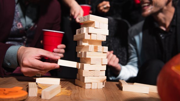 partial view of blurred friends playing wood blocks game during halloween party door LightField Studios (bron: shutterstock)